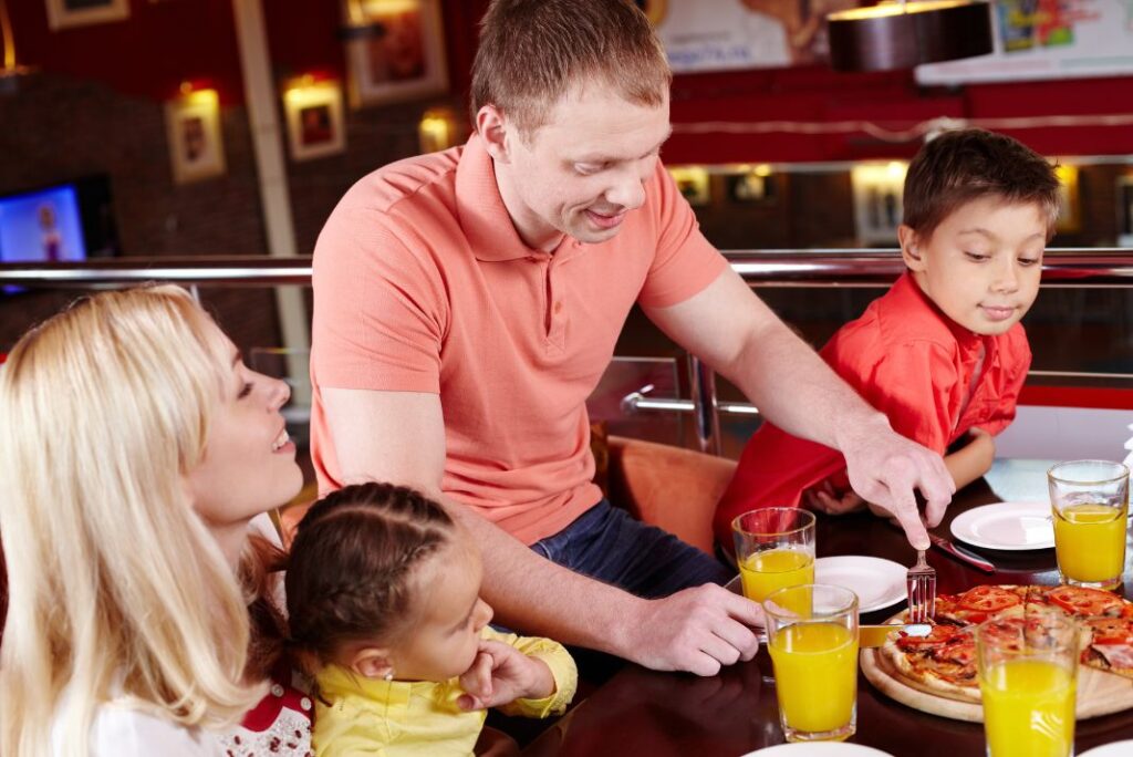 Family enjoying a kids eat free meal deal pizza